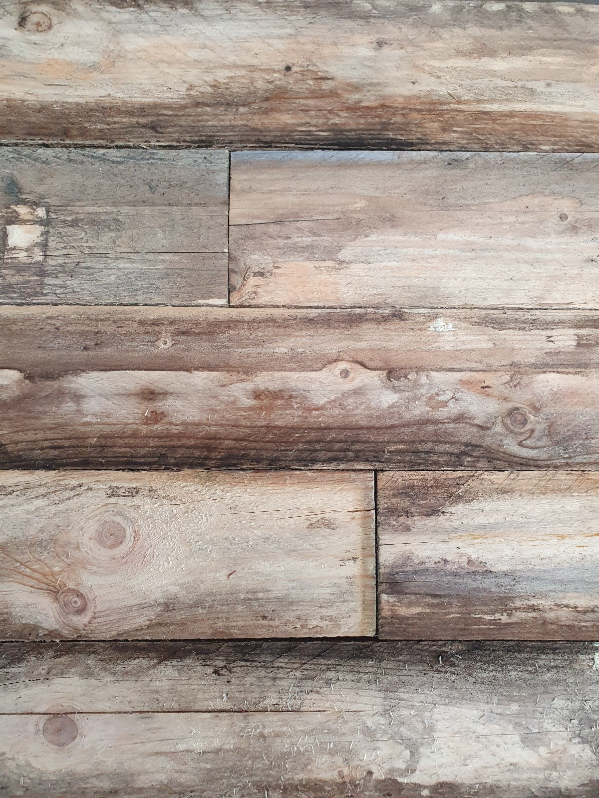 Detailopname van een gerecycleerde naaldhouten plank met natuurlijke onvolkomenheden en kleurvariaties, een perfecte keuze voor liefhebbers van ecologische en rustieke stijl.