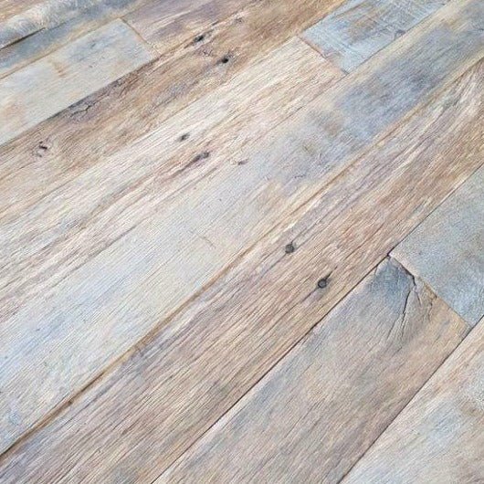 Gerecycleerd hout met charme: De zichtbare nagelkoppen op de oude planken vertellen een verhaal van jarenlang gebruik.